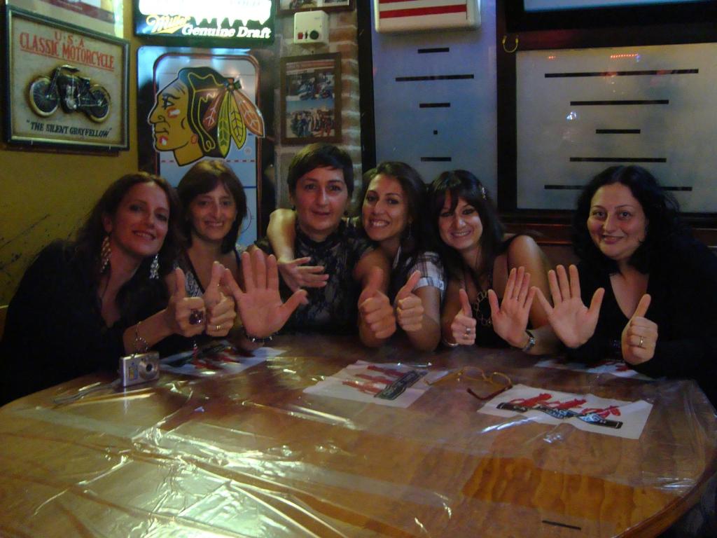 a group of people sitting at a table with their hands up at B&B 1646 Pozzilli in Pozzilli