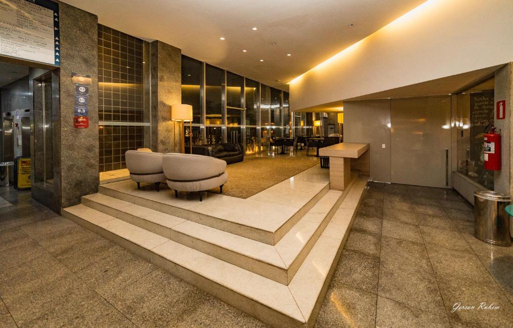 a lobby with a staircase in a building at Flat Premier 14 Max Savassi in Belo Horizonte