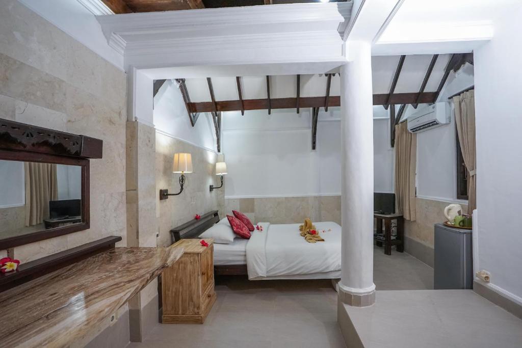 a bedroom with a bed and a television in a room at Martas Hotel in Gili Trawangan
