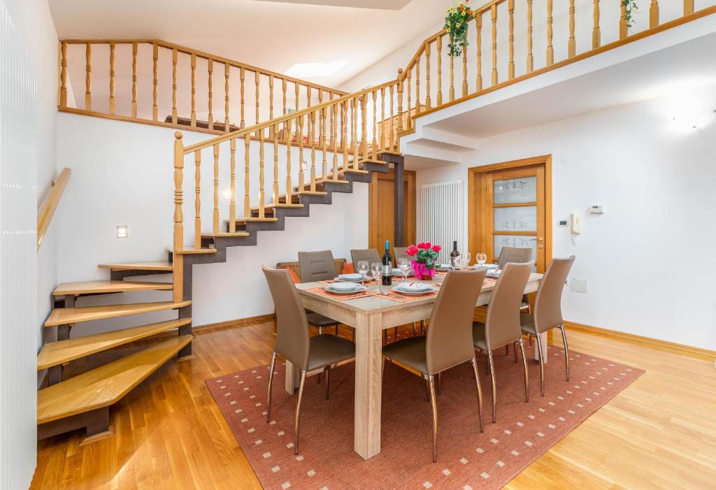 un comedor con mesa y sillas y una escalera en Apartment Villa Nera, en Pula