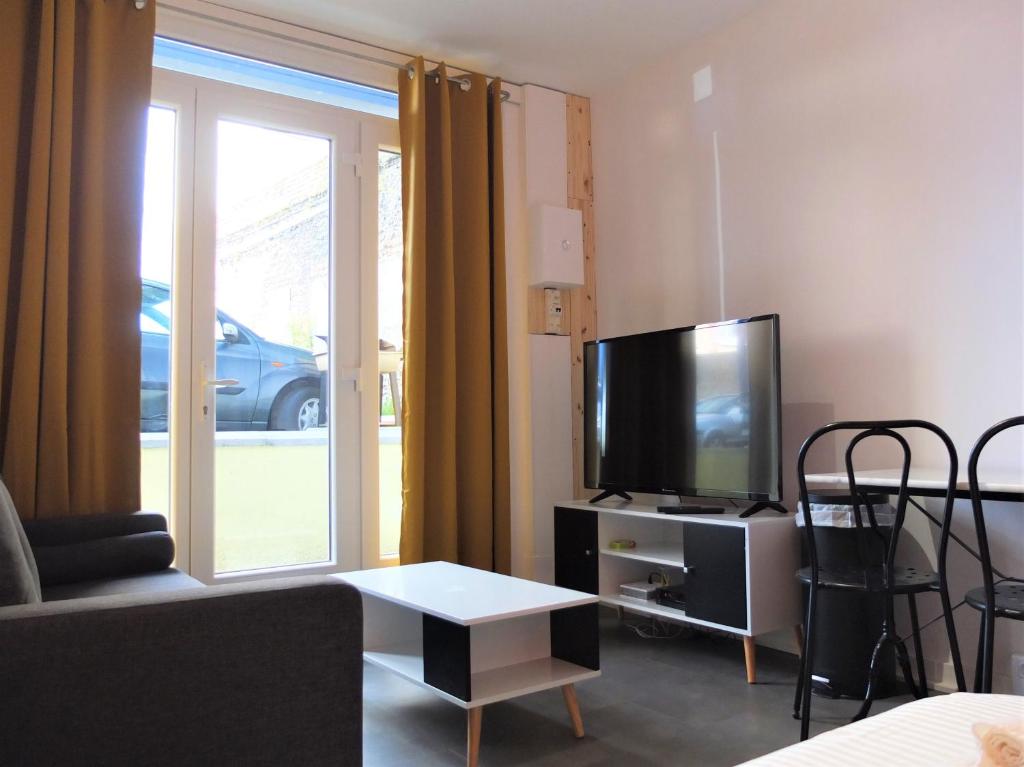 uma sala de estar com um sofá e uma televisão em Studio tout équipé - 300m gare - 005 em Rouen