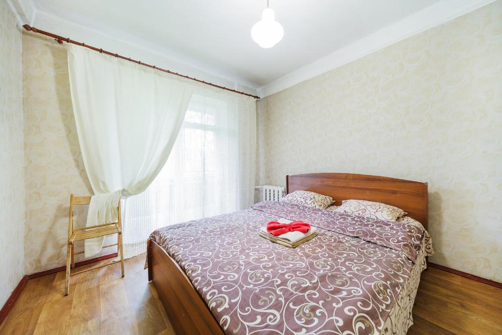 ein Schlafzimmer mit einem Bett mit einem roten Band darauf in der Unterkunft Квартира эконом-класса возле метро Левобережная in Kiew