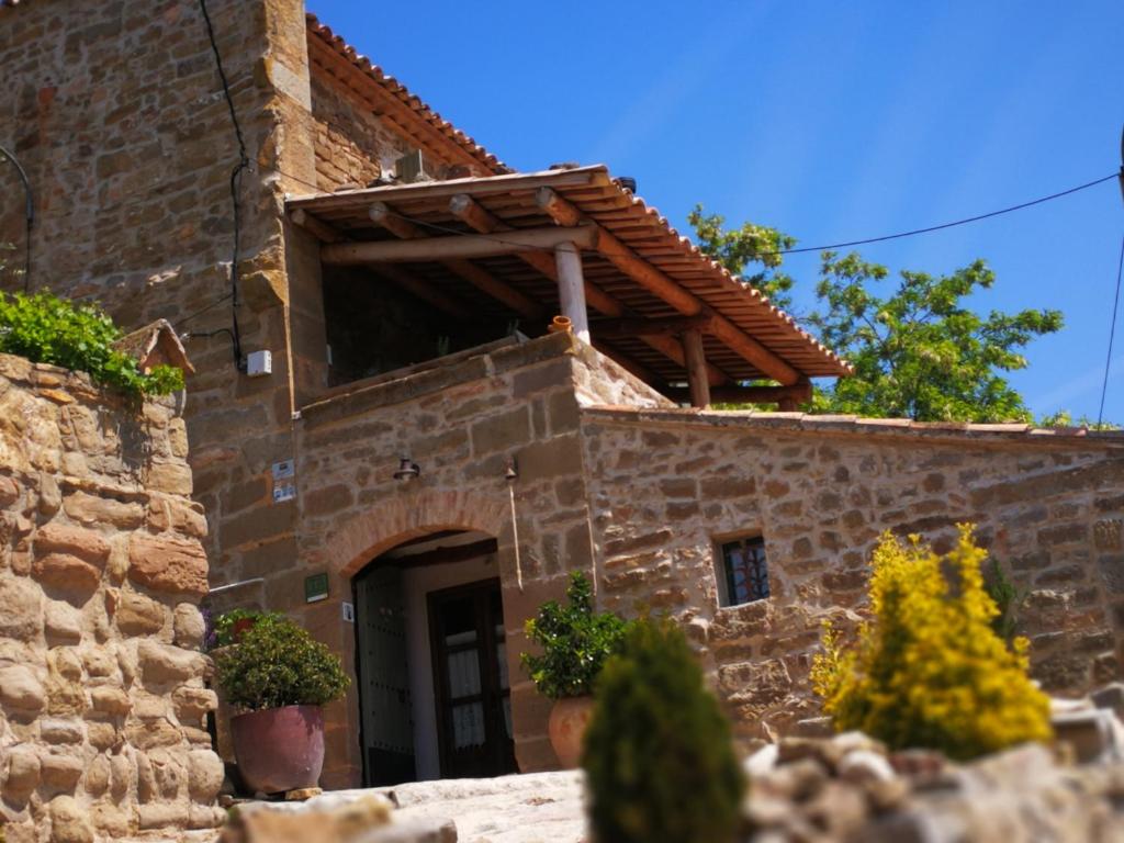 a stone building with a door and a window at La casa dels ocells in Granollers de Florejacs