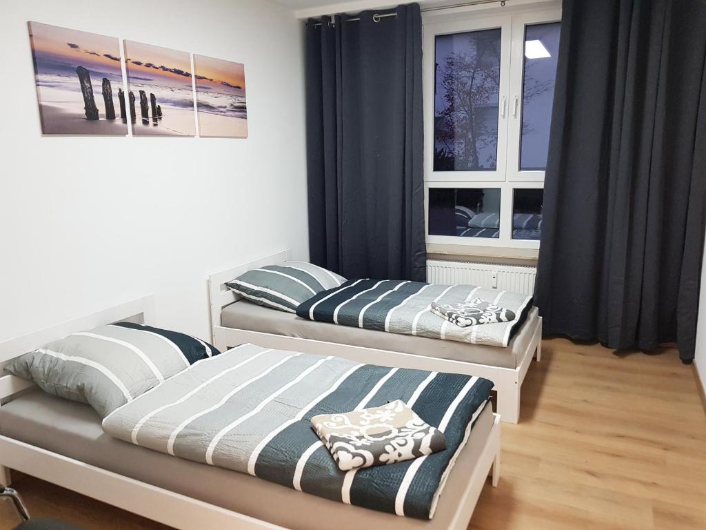 two beds in a room with two windows at My-Skypalace Neckarsulm in Neckarsulm