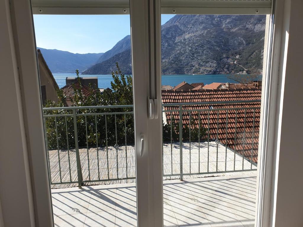 una puerta a un balcón con vistas al océano en Apartments Montenegro Risan Čučković, en Risan