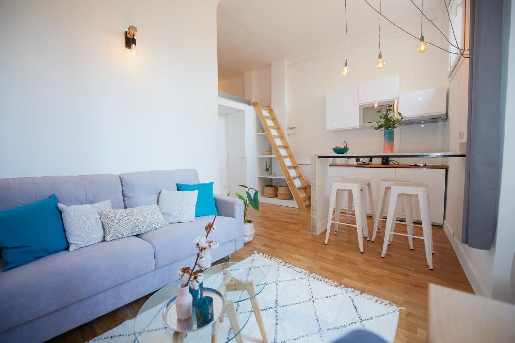 a living room with a blue couch and a kitchen at 6 Rue Coste Corail in Cannes