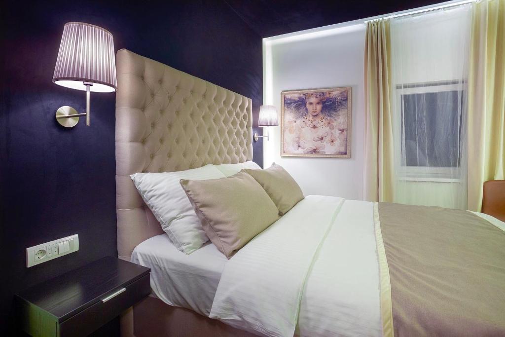 a bedroom with a large white bed and a lamp at 4Rooms 4U in Belgrade
