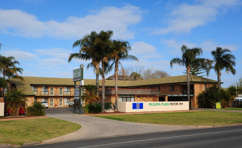 a building with palm trees in front of a road at Mildura Plaza Motor Inn in Mildura