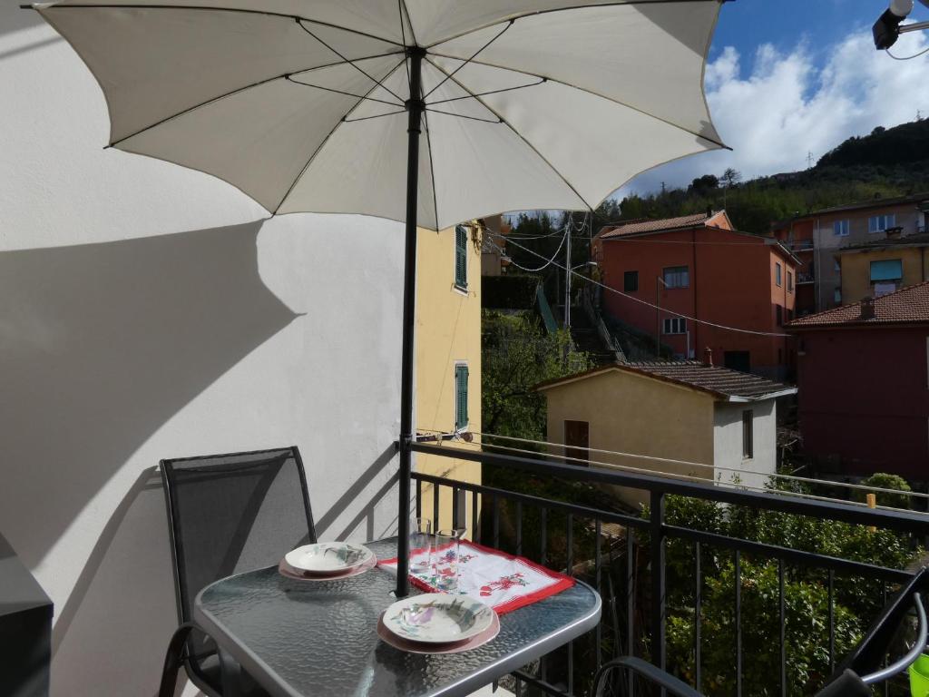 einen Tisch mit Sonnenschirm auf dem Balkon in der Unterkunft LA VALLETTA SUL MARE in La Spezia