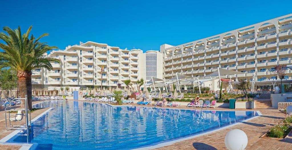 a swimming pool in front of a hotel at Hipotels Coma Gran in Sa Coma