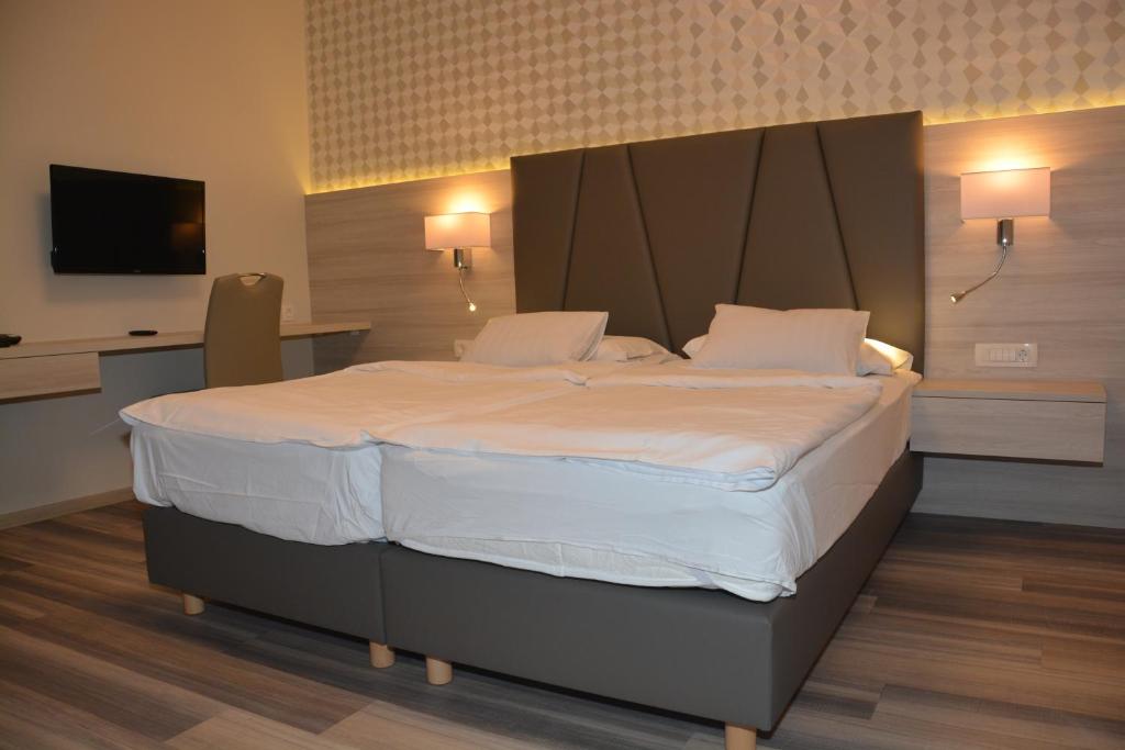 a bedroom with a large bed with white sheets and pillows at Hotel Fiesa in Piran