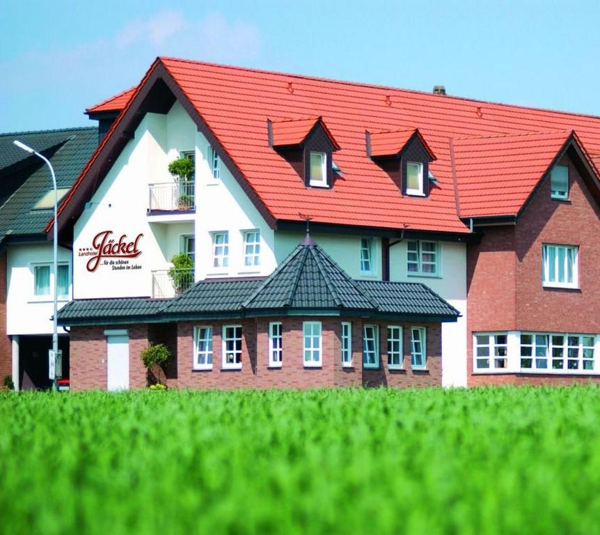 um grande edifício com um telhado vermelho em Landhotel Jäckel em Halle Westfalen