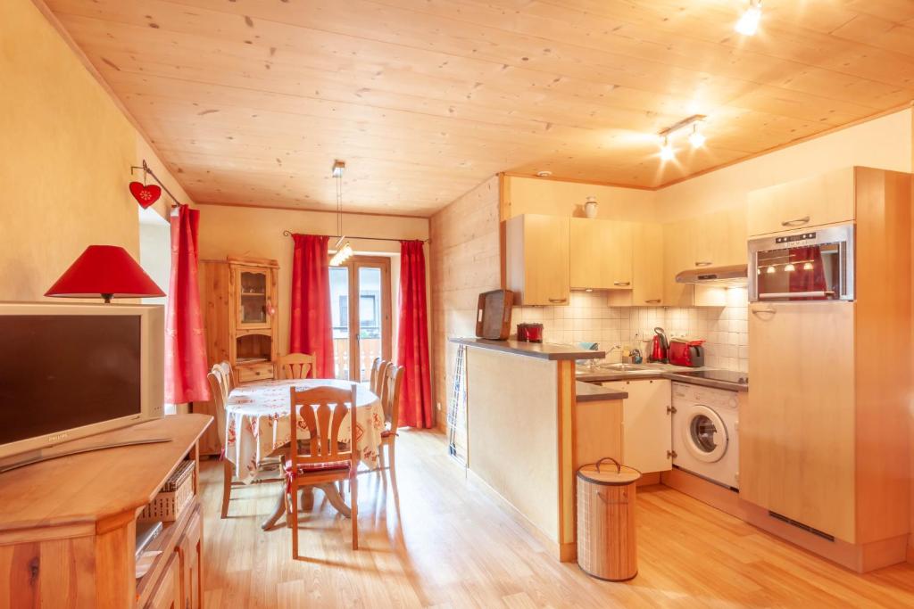 a kitchen and dining room with a table and chairs at PLACE EGLISE 2 in Morzine