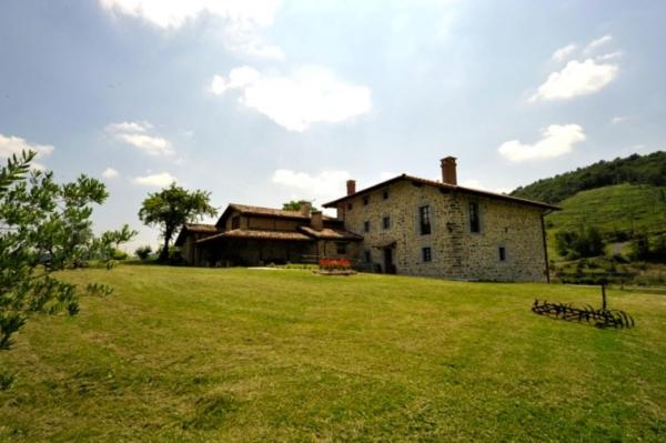 una vieja casa de piedra en un campo de hierba en Casa Rural Garabilla en Santa Coloma