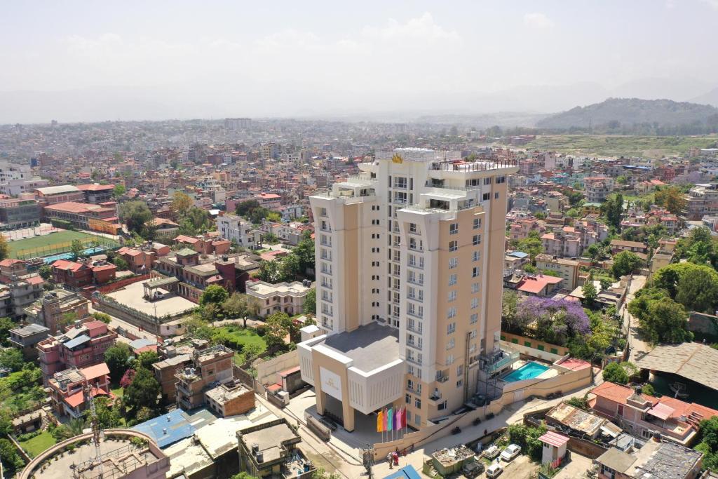 an aerial view of a city with a tall white building at Hotel Crowne Imperial in Kathmandu