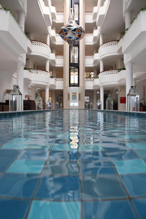 an indoor pool with blue water in a building at AP Oriental Beach - Adults Friendly in Portimão