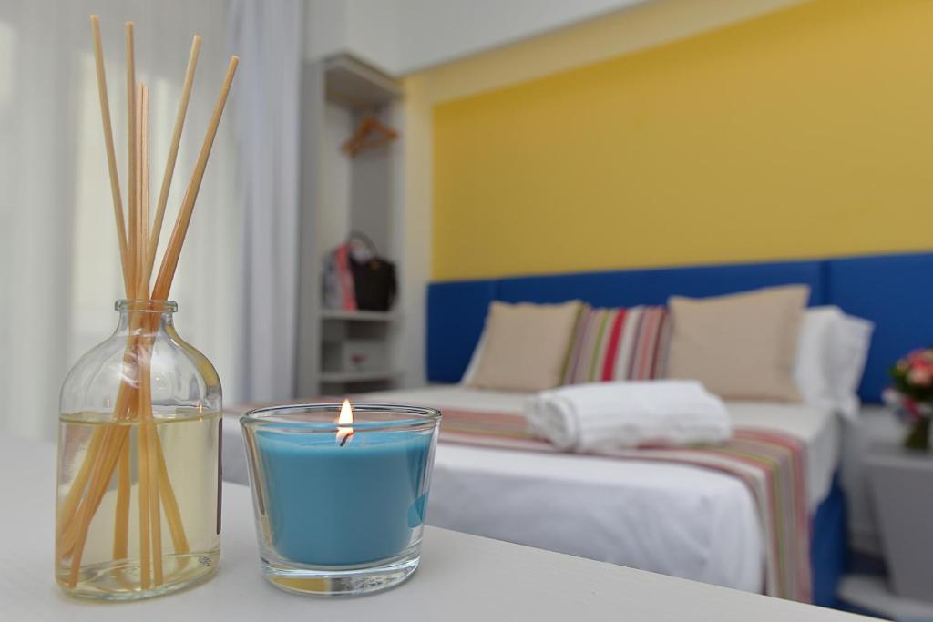 a candle and a vase on a table with a bedroom at San Domenico Accommodation Maiori in Maiori