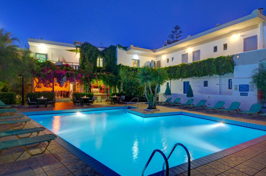a swimming pool in front of a house at night at Spacious Apartment in Plakias in Plakias