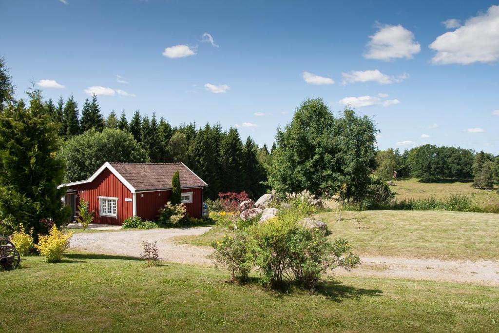 una casa rossa in mezzo a un campo di Ekeliden B&B a Ulricehamn