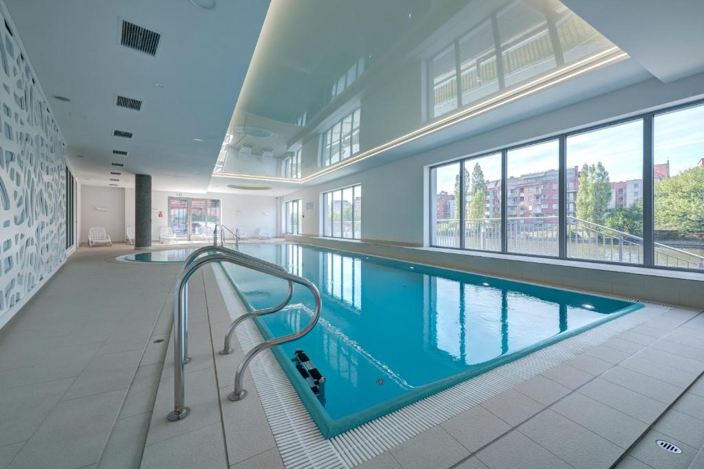 een groot zwembad in een gebouw bij Live & Travel Apartments - Waterlane Island in Gdańsk
