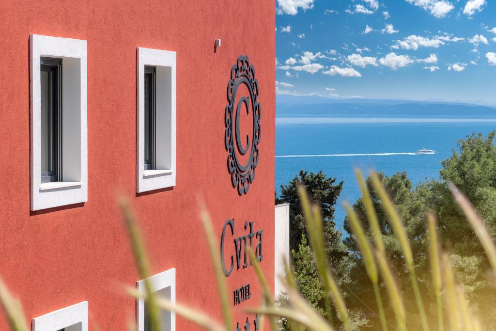 a red building with a view of the ocean at Hotel Cvita in Split