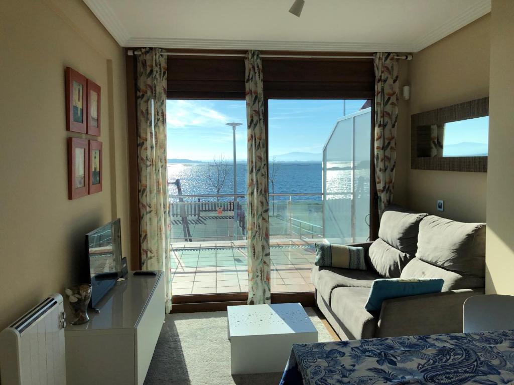 ein Wohnzimmer mit einem Sofa und einem großen Fenster in der Unterkunft Apartamento frente al mar in San Pedro