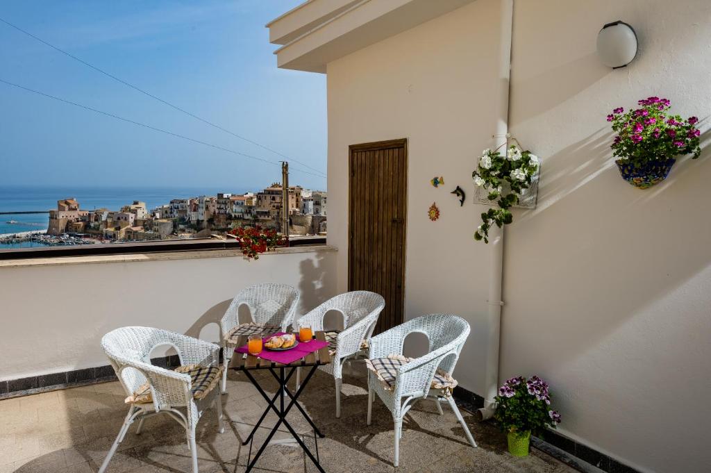 einen Tisch und Stühle auf einem Balkon mit Meerblick in der Unterkunft Casa dei Coralli in Castellammare del Golfo