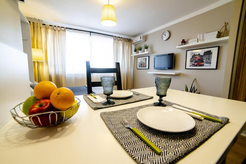 a kitchen with a table with a bowl of fruit on it at OpenApart - апарт Облака in Izhevsk