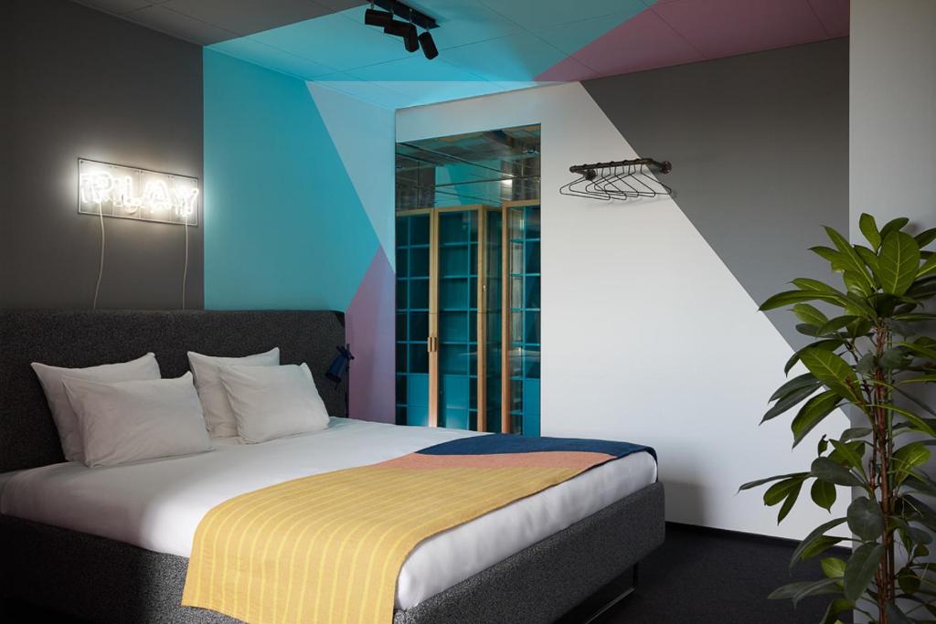 
a bedroom with a white bed and blue walls at The Student Hotel Rotterdam in Rotterdam
