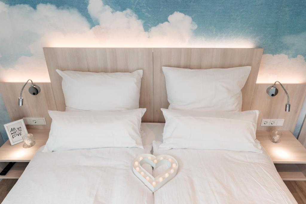 Una cama con un corazón y dos almohadas en Gasthaus Großenmeer en Ovelgönne