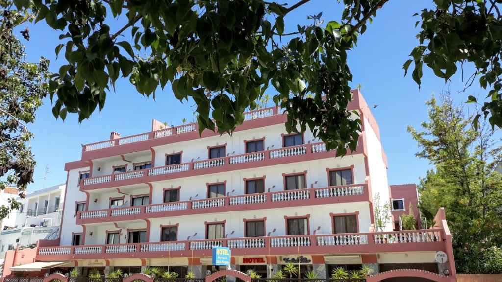 un gran edificio blanco con balcones rojos en Boutique Hotel Marina S. Roque en Lagos