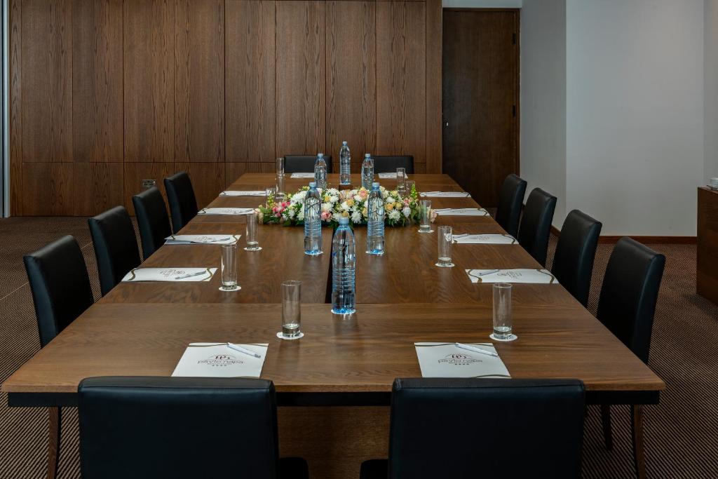 a conference room with a long wooden table with chairs at Pavlo Napa Beach Hotel in Ayia Napa