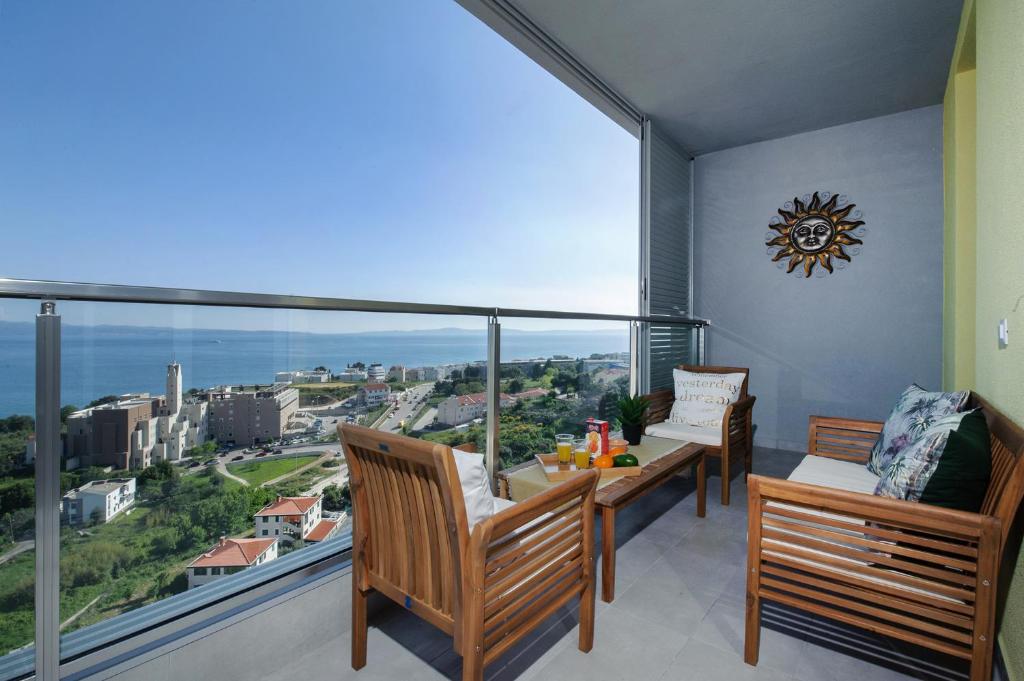 un balcón con 2 bancos y una ventana grande en Sea view Tiho Apartment en Split