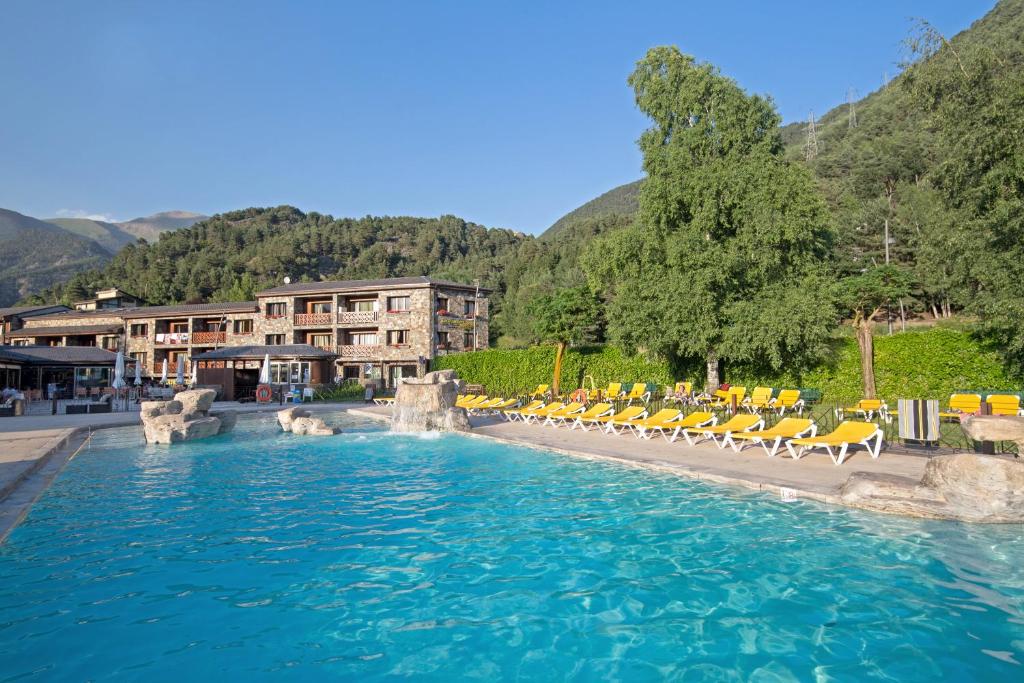 una grande piscina con sedie e un hotel di Apartaments Giberga a LʼAldosa