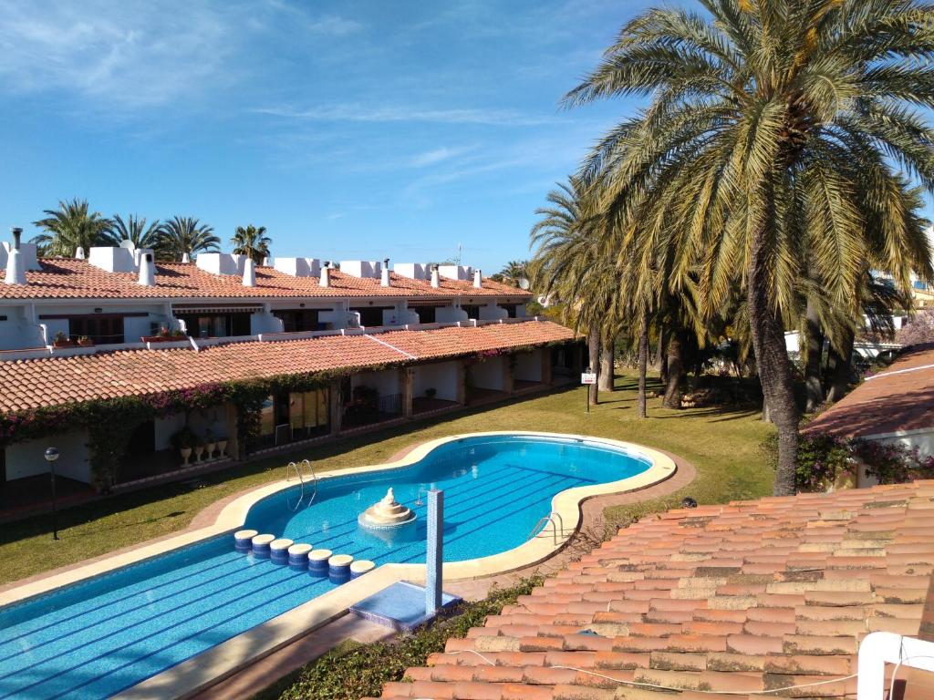 een zwembad voor een gebouw met palmbomen bij Casa Nova Adele + Pelletsoffen in Denia