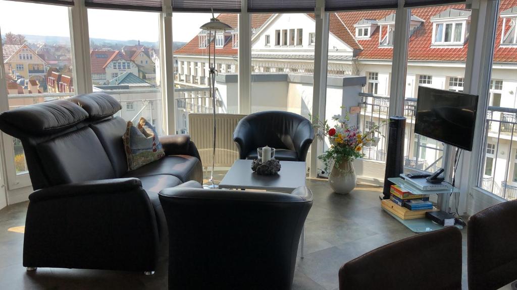 a living room with chairs and a table and a television at Haus Meeresblick Whg. 4.11 in Kühlungsborn