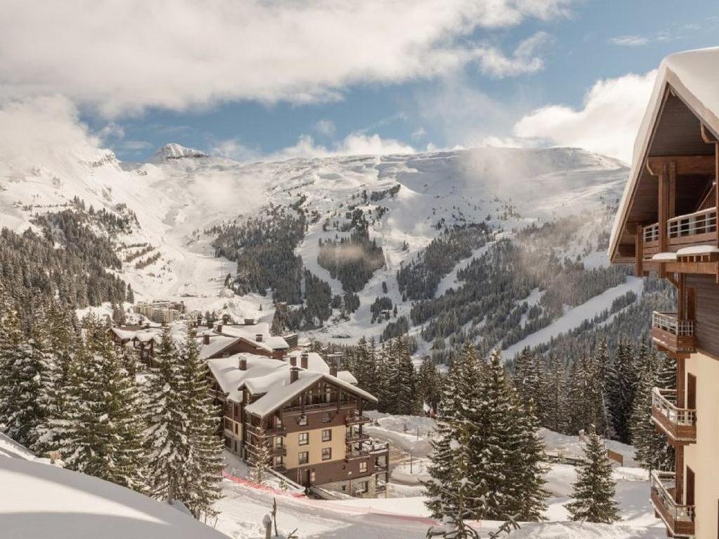 um alojamento de esqui nas montanhas com neve no chão em Flaine prime ski in, ski out Apartment em Flaine