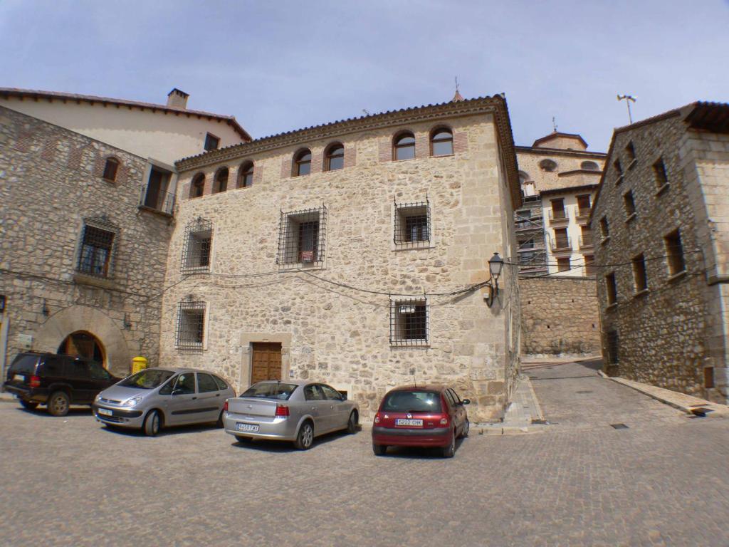 a group of cars parked in front of a stone building at 1 P Casa de los Fernandez Rajo in Orihuela del Tremedal