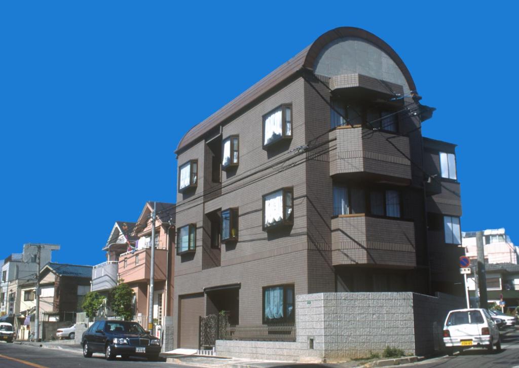 ein Gebäude auf einer Straße mit davor geparkt in der Unterkunft Nakagawa's Cozy House in Sakai