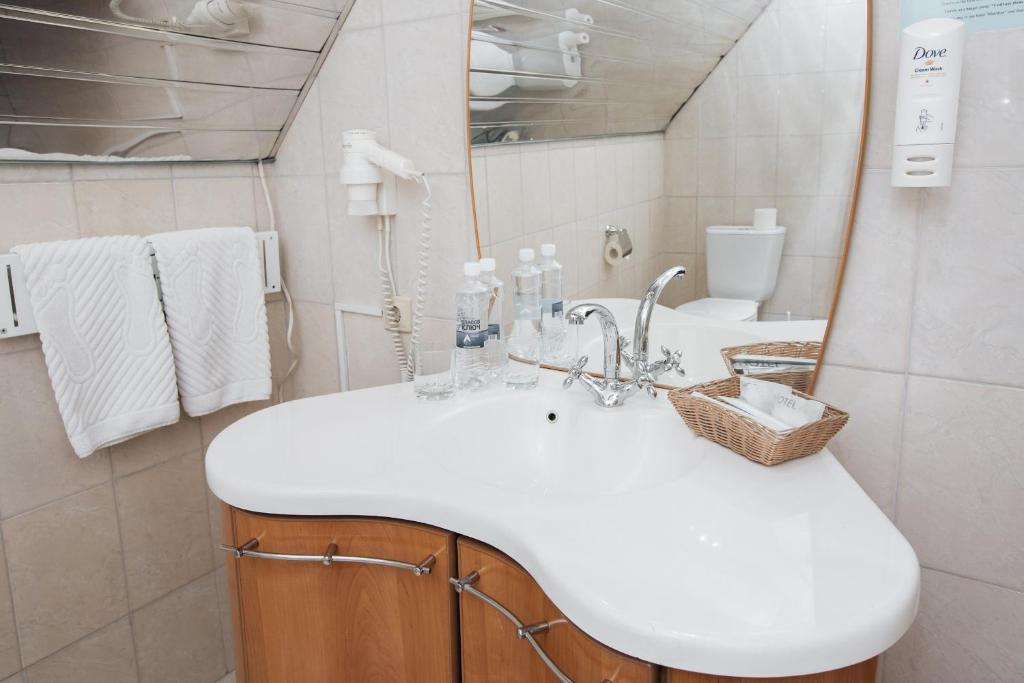 a bathroom with a white sink and a toilet at Hotel Meridian in Chelyabinsk