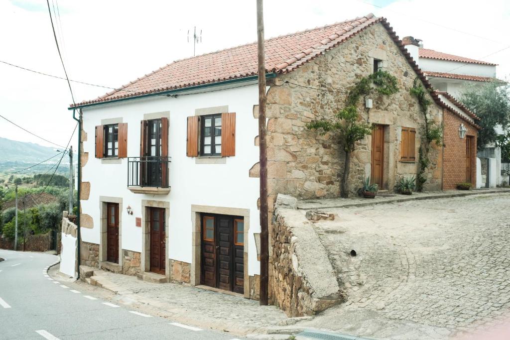 una casa vieja al lado de una calle en The Bakery Guesthouse en Fundão