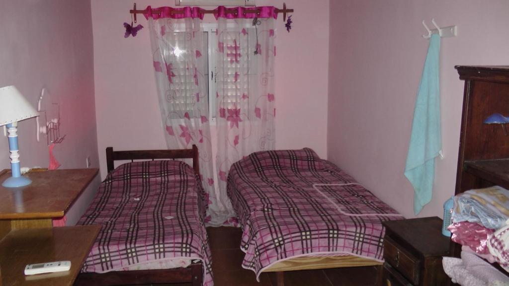een slaapkamer met 2 bedden, een tafel en een raam bij TERRAZA AL RIO 2 in Paso de la Patria