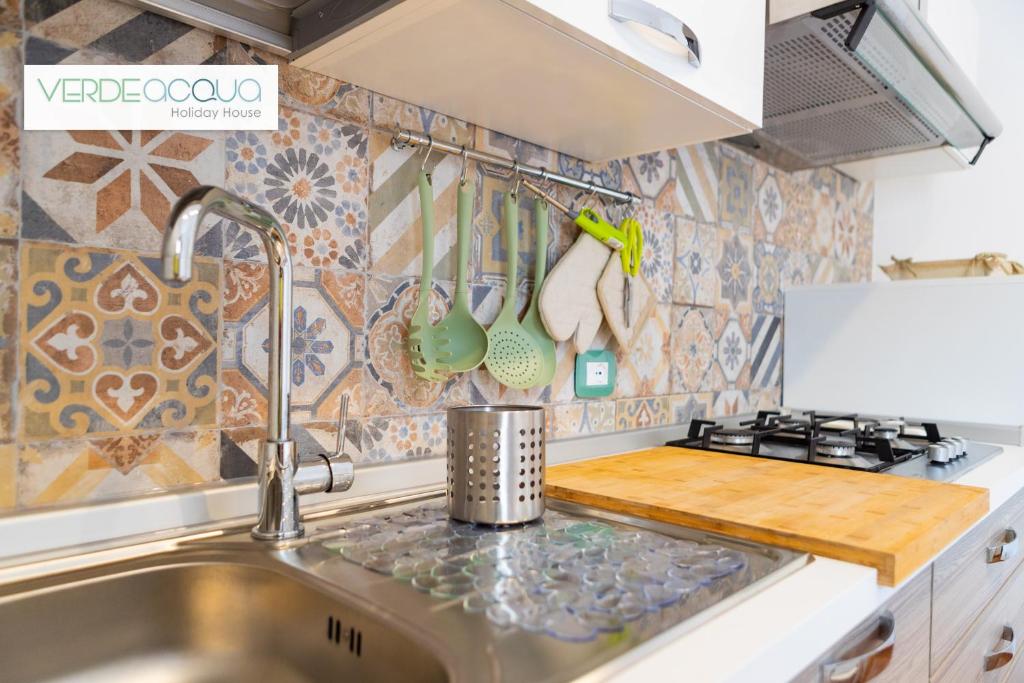 a kitchen with a sink and a stove top oven at Verdeacqua Holiday House in Marinella di Selinunte