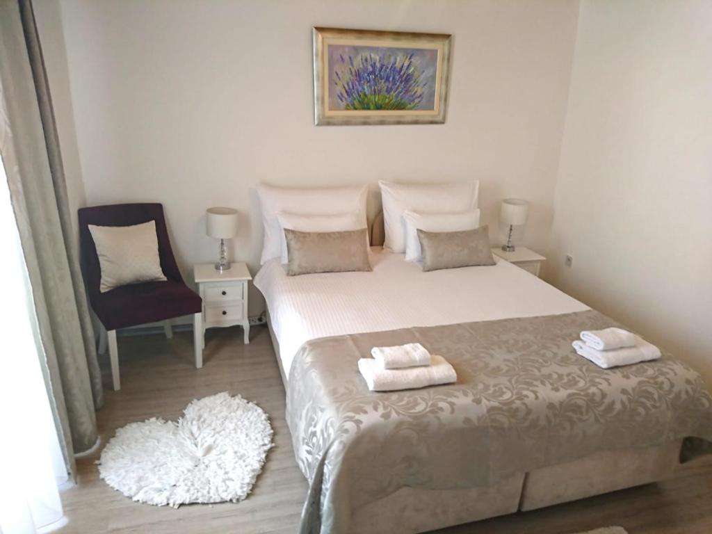 a bedroom with a large bed and a chair at Studio Sfinga in the heart of Diocletian's palace in Split