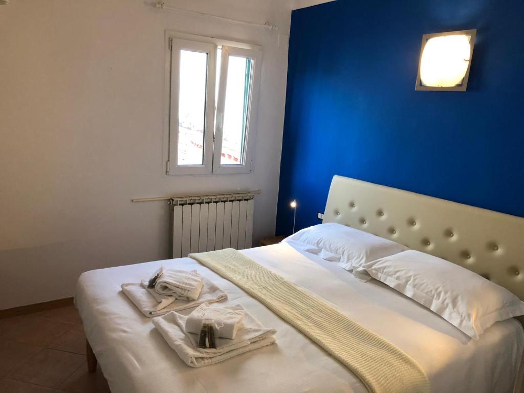 Piaggione Apt, Case Galante Apartments in Florence في فلورنسا: غرفة نوم زرقاء مع سرير عليه مناشف