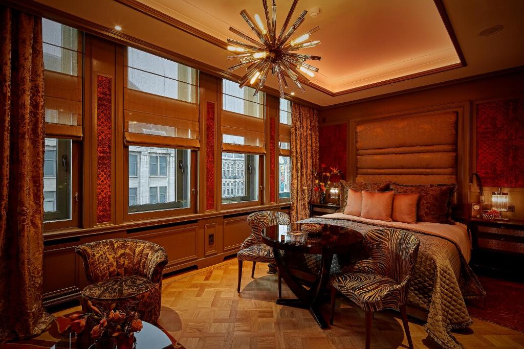 ein Schlafzimmer mit einem Bett und einem Tisch und Stühlen in der Unterkunft Hotel TwentySeven - Small Luxury Hotels of the World in Amsterdam