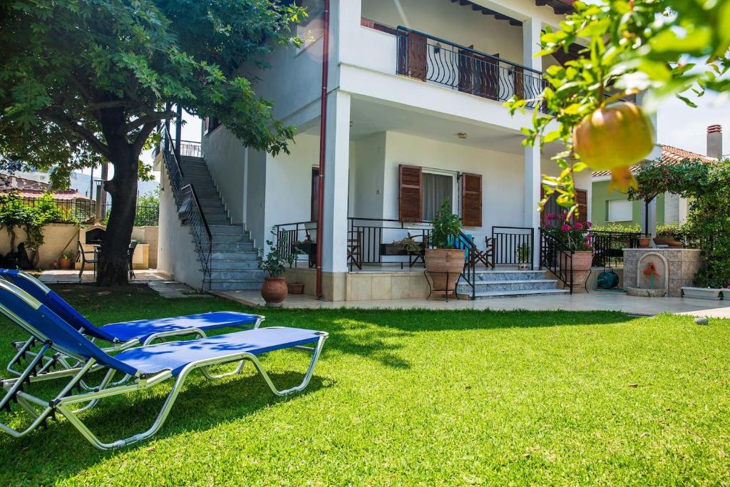 a pair of lounge chairs in the yard of a house at Villa Pleiades #1 in Nea Vrasna
