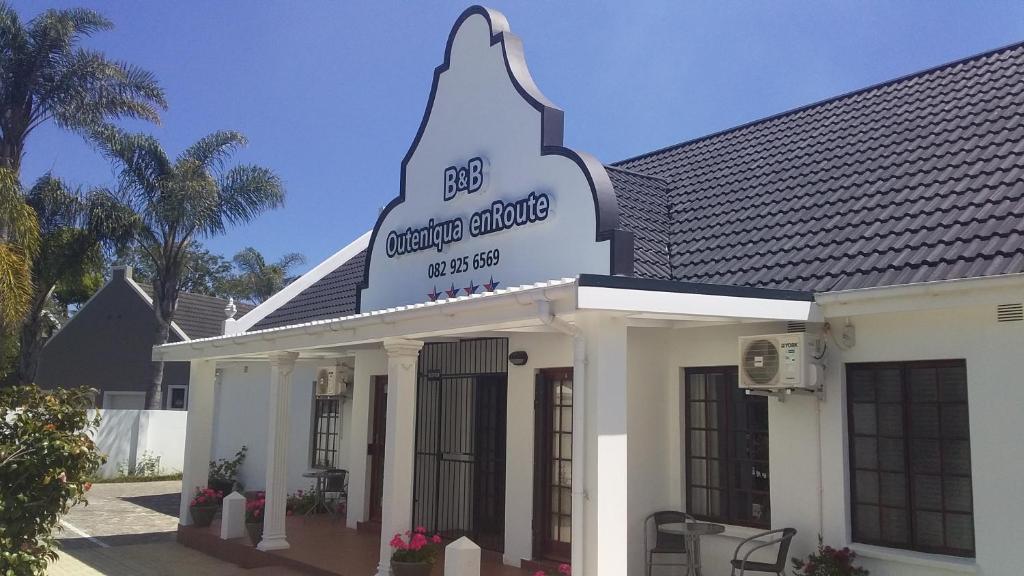 a white building with a sign on top of it at Outeniqua en Route in George