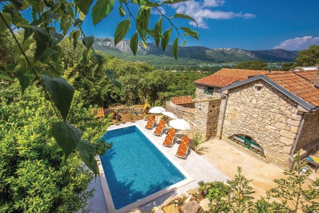 uma vista exterior de uma villa com piscina em Villa Mediteran em Tribalj