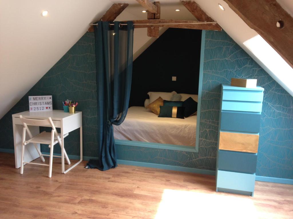 a bedroom with a bed and a desk in a attic at houlliere in Domjean